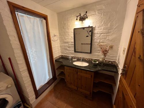 un bagno con un lavandino, uno specchio e una finestra di El Diablo Chic - Altos de la Viuda a Punta Del Diablo