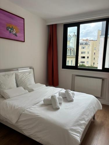 une chambre avec un lit blanc avec deux oreillers dessus dans l'établissement Room Iéna boissière, à Paris