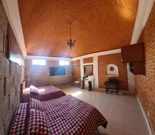 a bedroom with two beds with a checkered blanket at Casa Müi in Tequisquiapan