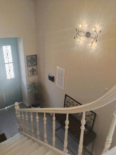 a white staircase with a chandelier on the wall at 1920 Classic in Kalamata