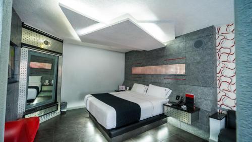 a bedroom with a large bed and a red chair at Kuboz Motor Hotel (Motel y Hotel) in Guadalajara