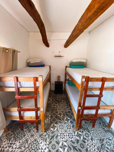 two bunk beds in a small room with wooden beams at Rey Lagarto Hostel in San Pedro de Atacama