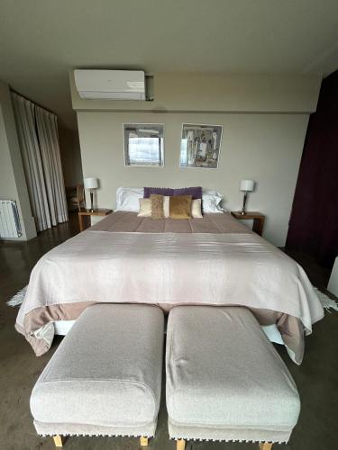 a bedroom with a large bed with two benches at Casa de Huéspedes La Azul in Los Árboles
