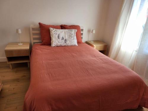 una camera da letto con un letto con una coperta rossa e una finestra di Nice Fac St Jean D'Angely a Nizza