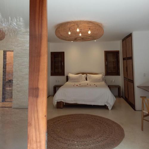 a bedroom with a bed and a chandelier at Villa Praia - La Villa Group in Jericoacoara