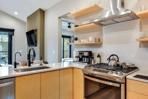 a kitchen with a stove top oven next to a sink at The Birdhouse - Lake View with Dock in Mooresville