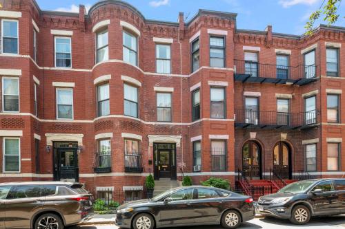two cars parked in front of a brick building at Brownstone Townhouse in Fenway in Boston