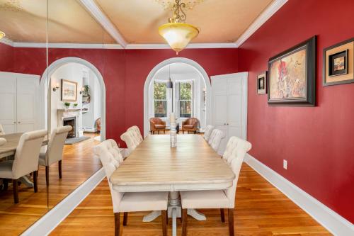 a dining room with a long table and white chairs at Brownstone Townhouse in Fenway in Boston