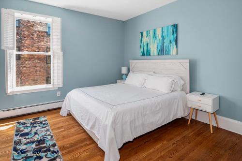 a blue bedroom with a bed and a window at Brownstone Townhouse in Fenway in Boston