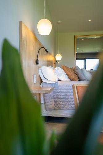 a bedroom with a bed with pillows and a mirror at Casa de Huéspedes La Azul in Los Árboles