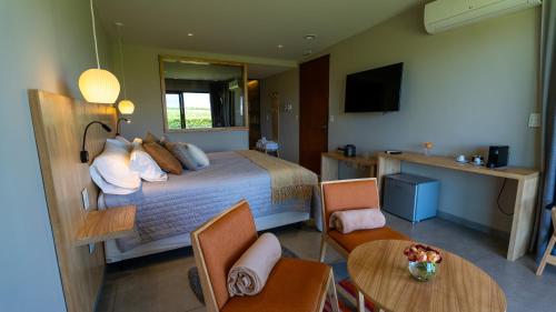 a hotel room with a bed and a table and chairs at Casa de Huéspedes La Azul in Los Árboles