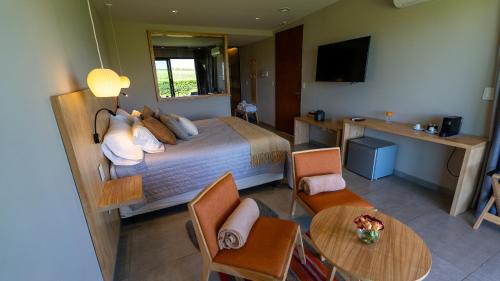a hotel room with a bed and a table and chairs at Casa de Huéspedes La Azul in Los Árboles