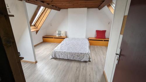 Cette petite chambre comprend un lit et deux fenêtres. dans l'établissement Maison à Binic, à Gicquel