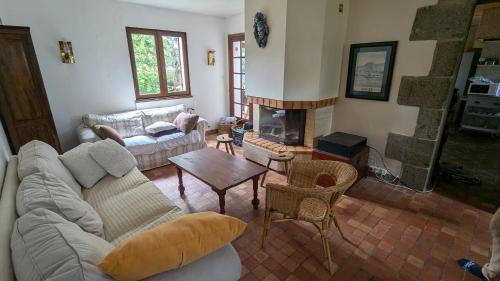 un salon avec un canapé et une cheminée dans l'établissement Maison à Binic, à Gicquel