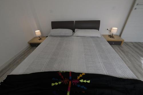 a bedroom with two beds and two lamps on tables at BB Il benvenuto in Loreto