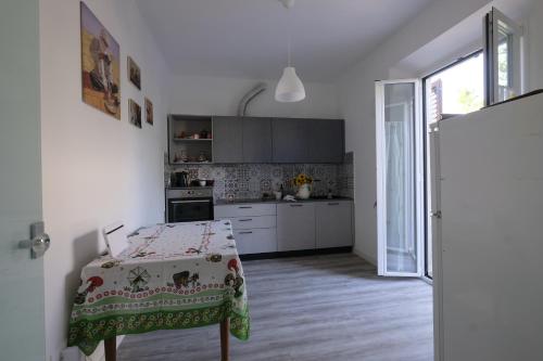 a white kitchen with a table and a kitchen with a window at BB Il benvenuto in Loreto