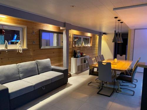 un salon avec un canapé et une salle à manger dans l'établissement Le Grand Charlyse, de 1 à 10 personnes, à Stotzheim