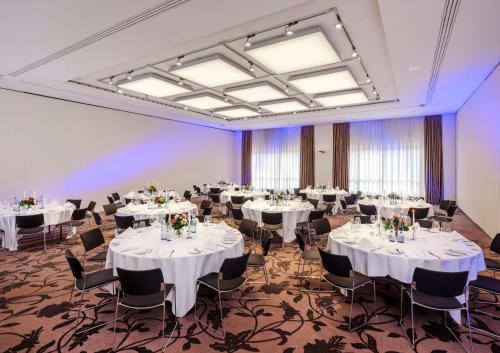 a banquet hall with white tables and chairs at Dorint Hotel Bremen in Bremen