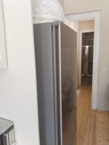a stainless steel refrigerator in a room with a mirror at 1920 Classic in Kalamata