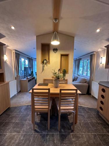 a kitchen and dining room with a table and chairs at 56 Main Park Caravan Hire Lillardsedge Holiday Park Jedburgh in Jedburgh