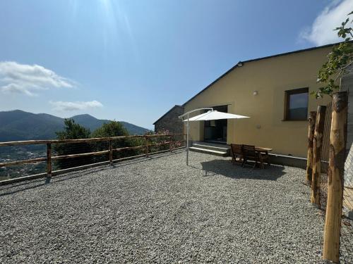 a patio with a table and an umbrella at Tuvo Houses in Levanto