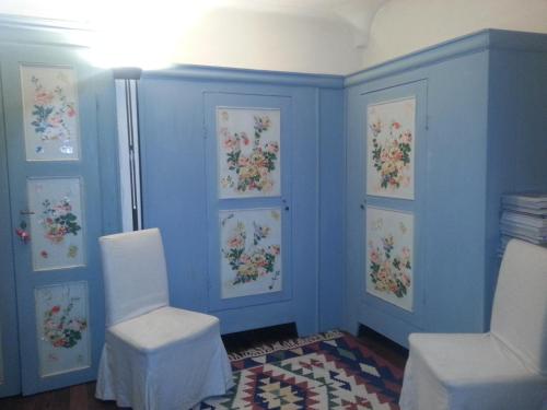 a room with two white chairs and blue walls at Antica Cascina del Medico in Muzzano