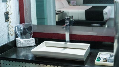 a bathroom counter with a sink and a mirror at Kuboz Motor Hotel (Motel y Hotel) in Guadalajara