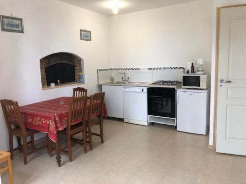 une cuisine avec une table et une cuisine avec une cuisinière dans l'établissement La ferme de Sidoine, à Beaumerie-Saint-Martin