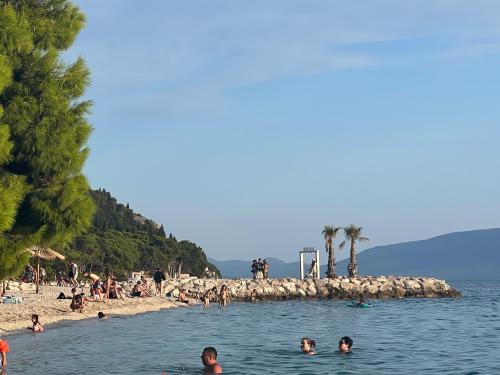 a group of people swimming in the water at a beach at Apartments Mateljak in Gradac