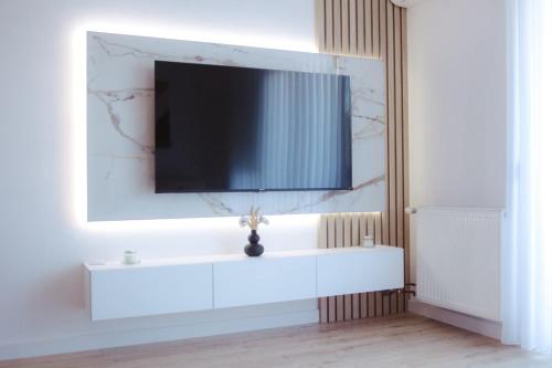 a living room with a tv on a white wall at Lux Apartmani Teslić in Teslić