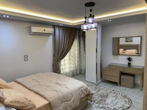 a bedroom with a bed and a dresser and a mirror at شقة فندقية على النيل in Mansoura
