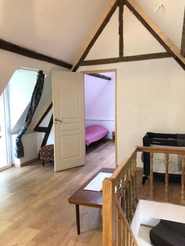 une chambre mansardée avec une porte et une chambre avec un lit dans l'établissement La ferme de Sidoine, à Beaumerie-Saint-Martin