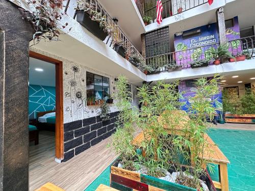 a hotel with a swimming pool and plants in the courtyard at El Jardín Escondido by Soma in Baños