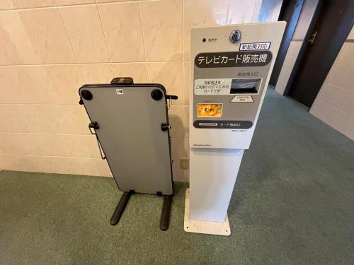 a ticket machine sitting next to a wall at 青森フォレストホテル アネックス in Aomori
