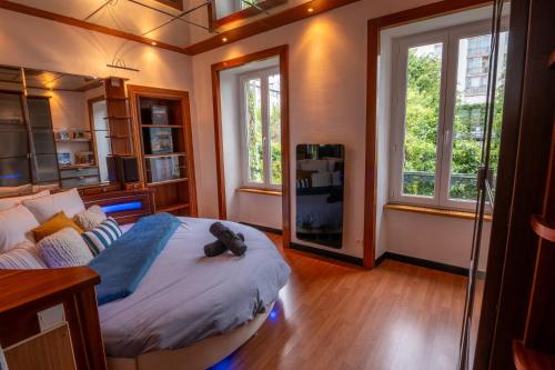 a bedroom with a bed with a teddy bear on it at Cocon atypique en rive droite in Brest