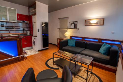 a living room with a couch and a kitchen at Cocon atypique en rive droite in Brest