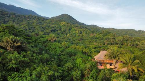 a house in the middle of a lush green mountain at Frana Lodge in El Zaino
