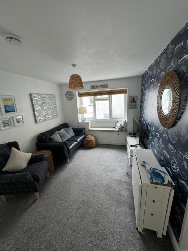 a living room with a couch and a table at Plain Sailing 2 min walk to the harbour amazing location in Brixham