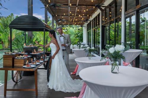 a bride and groom standing in front of a buffet of food at El Beso Adults Only at Ocean Riviera Paradise All Inclusive in Playa del Carmen