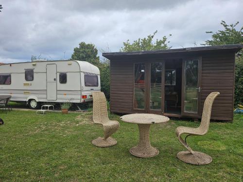 two chairs and a table in front of a trailer at Tranquil Equestrian Escape - Sleeps 2 in Trusthorpe