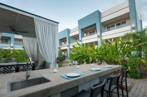 an outdoor table with chairs and a sink in front of a building at Blue Haven Holiday Apartments in Christ Church
