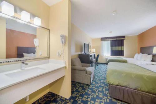 a hotel room with a bed and a sink at Quality Inn O'Fallon IL - St Louis in O'Fallon