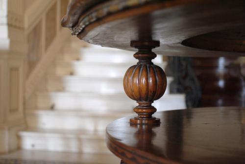 a close up of a wooden table with stairs in the background at Villa Tina Hotel in Viareggio