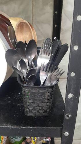 a basket of silver utensils on a shelf at Casa espaçosa bem localizada em Maricá! in Maricá