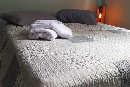 a white towel is laying on a bed at Casa espaçosa bem localizada em Maricá! in Maricá