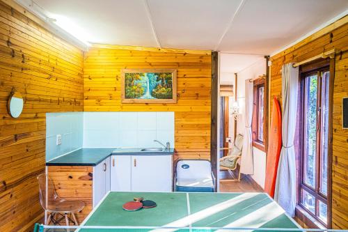 サウスブルームにあるSouthbroom River Houseの木製の壁のキッチン、テーブルが備わります。