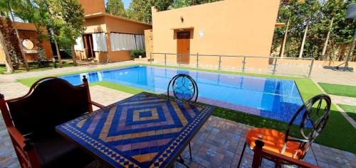 a table and chairs next to a swimming pool at Villa de luxe à marrakech in Marrakech