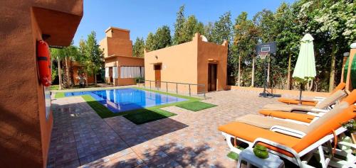 a swimming pool with lounge chairs and a house at Villa de luxe à marrakech in Marrakech