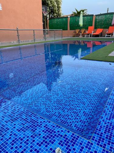 a swimming pool with blue tiles in a resort at Villa de luxe à marrakech in Marrakech