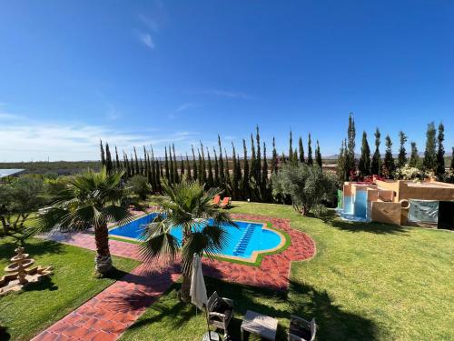 a resort with a swimming pool and palm trees at Villa de luxe à marrakech in Marrakech
